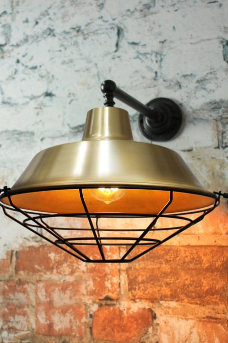 Bright brass wall light with cage guard