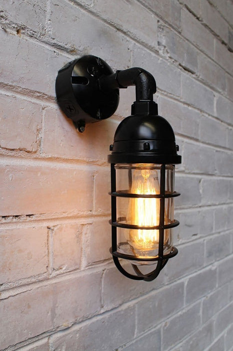 Bunker cage wall light has edison bulb