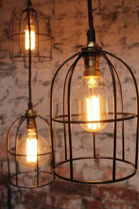 Cage industrial pendant light available in antique brass or black cage shade.