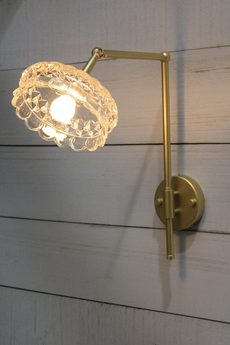 Charmont wall light in gold finish, tilted position;