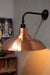 Polished copper shade with matt black wall sconce
