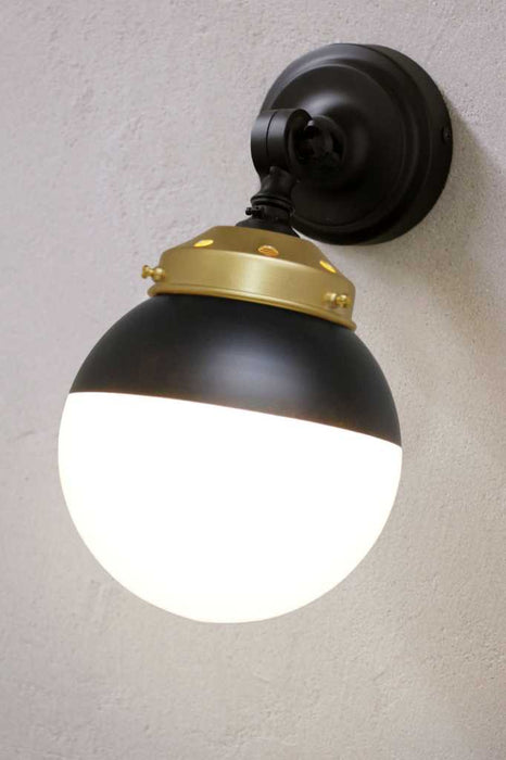 Crown Sphere Swivel Arm Wall Light with a black mounting arm, gold gallery and a black and opal shade