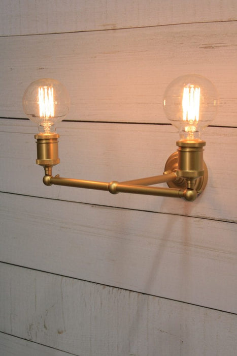 Double arm wall sconce in gold