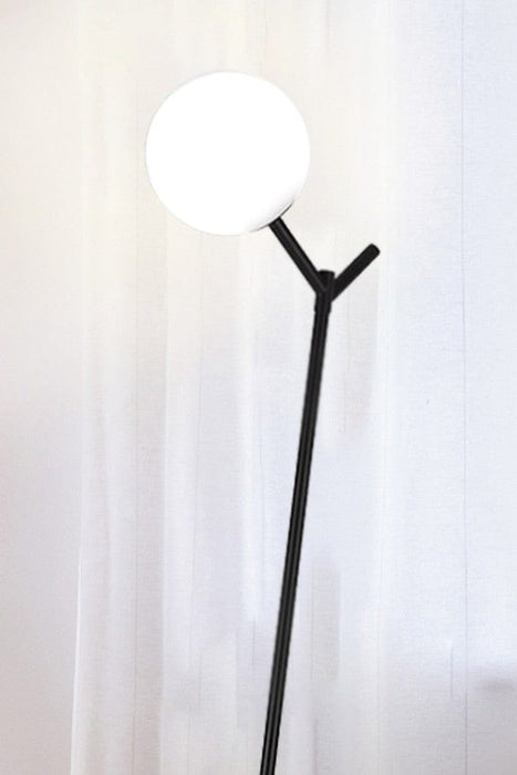 Top section of black floor lamp with opal glass shade