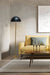 Gold/brass floor lamp with black shade in room