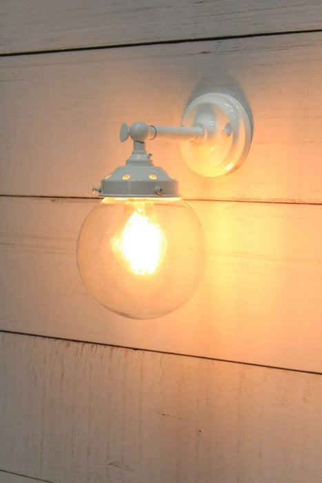 Glass ball wall light with short white arm and small clear shade