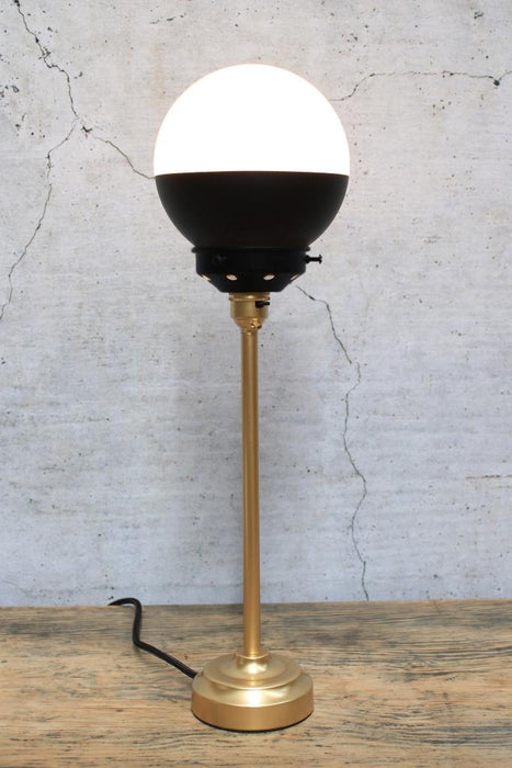 Table lamp with gold base and black gallery and shade