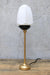 Gold table lamp with black gallery turned off