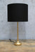 Gold table lamp with black fabric shade turnedoff