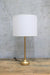 Gold table lamp with white shade turned off