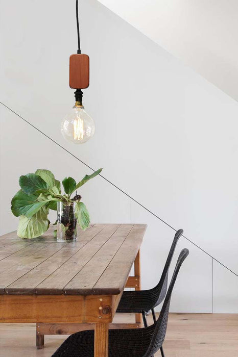 Wood block pendant light over dining table.