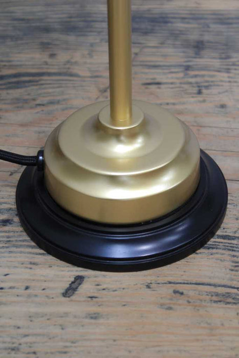 gold table lamp on a black wooden mounting block 