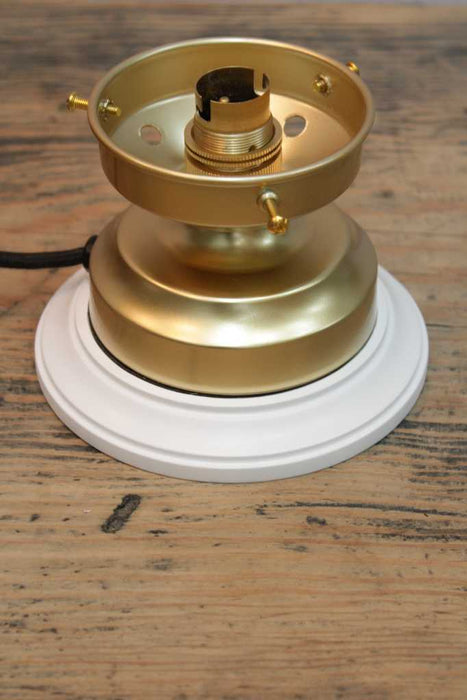 white mounting block on a gold table lamp fixture