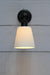 Front view of wall light with black finish and large white ceramic shade
