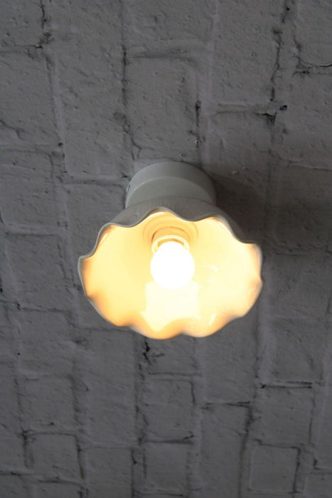 Ceramic light flush mounted on brick wall. 