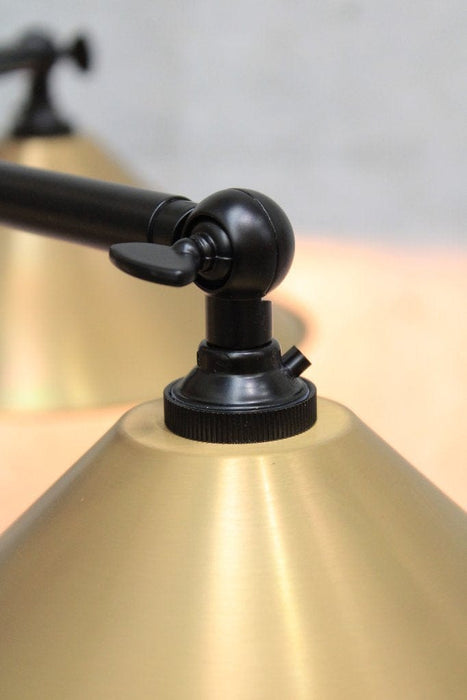 Aged brass cone shade and arm close up