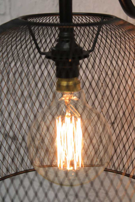 Detail of light bulb seen through metal basket shade