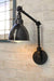 Industrial two arm swing wall lamp with black enamel shade and large round edison bulb