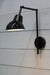 Black wall sconce with black and white shade