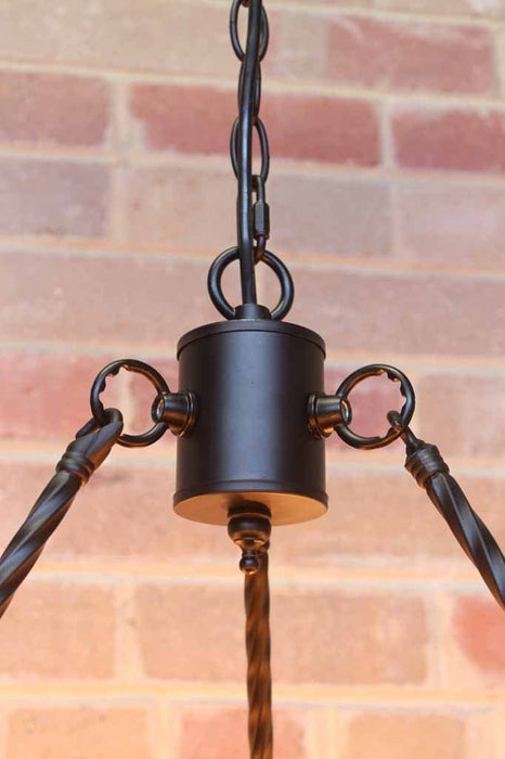 Lodge chandelier has a centerpiece that holds the 3 tisted metal rods to the chain suspension