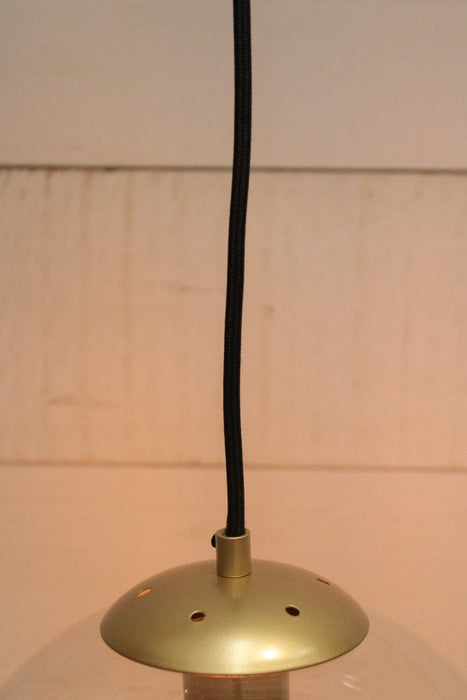 globe glass pendant light  close up on metalware in gold