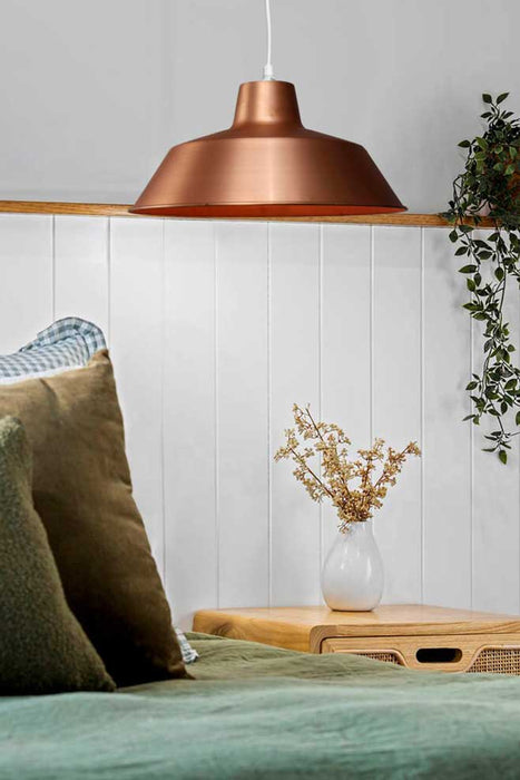 Bright Copper Factory Pendant Light over a night table
