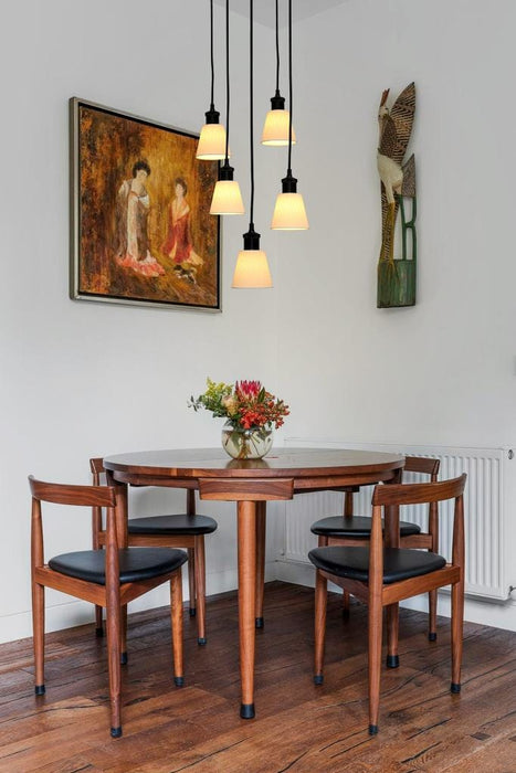 Black five light pendant with large ceramic shades over dining table