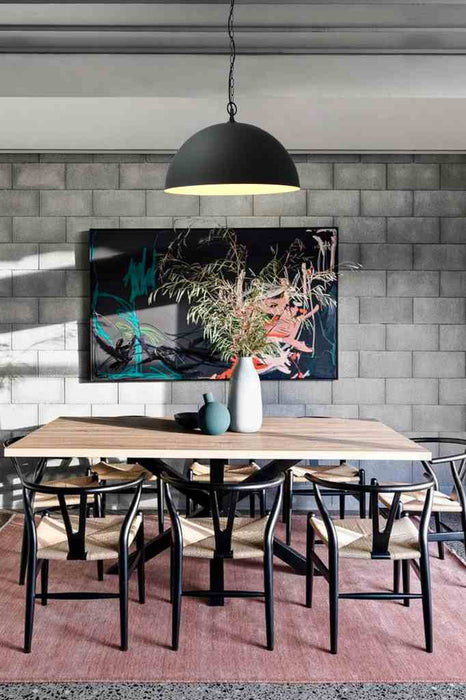Dome pendant light in black with black side entry chain hung above dining table. 