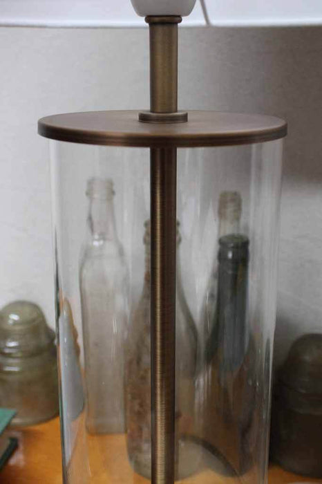Pushbar switch lamp. aged brass finish. clear glass table lamp base.