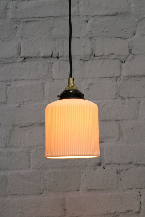 Ribbed ceramic pendant light with gold/brass cord
