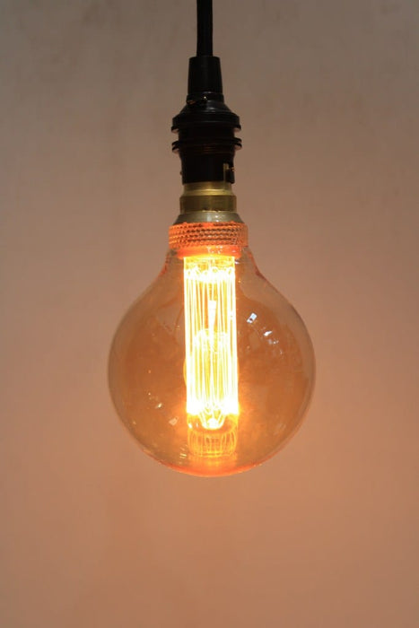 Round amber bulb with laser-cut LED filament on pendant cord