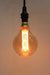 Round amber bulb with laser-cut LED filament on pendant cord