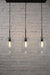 Three light linear pendant with cylinder shades and black ceiling rose