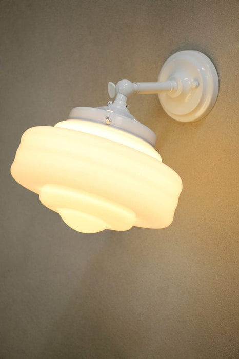 Schoolhouse glass wall light in white steel finish in tilted position