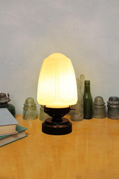 Nouveau glass lamp with black base on table