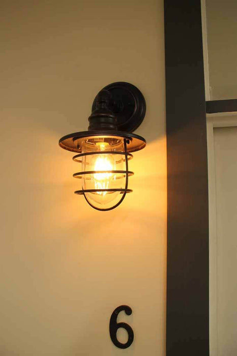 The clear glass cover also has an antique bronze cage covering for added appeal. this wall light has an IP44 rating