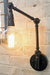 Two arm swing wall lamp has industrial styling