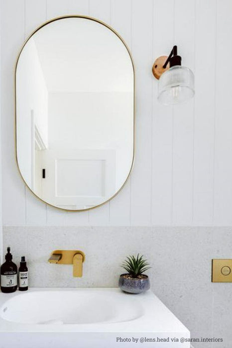 Glass wood wall light mounted next to the bathroom mirror. 