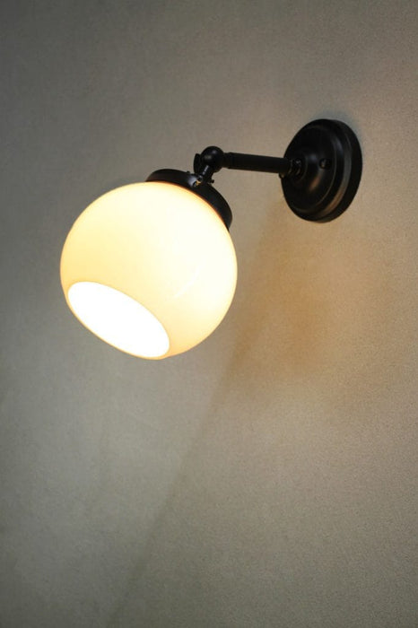 small black wall light with small opal shade