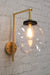 Gold wall sconce with medium clear shade