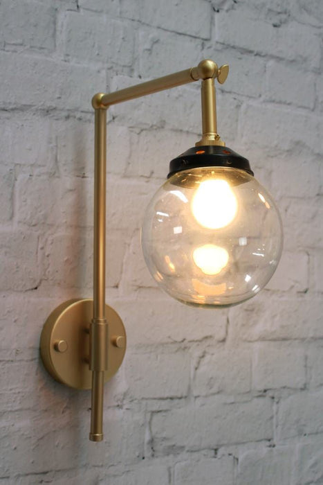 Gold wall sconce with clear small shade