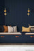 Gold/brass wall lights on blue wall above bench seat