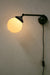 Long black adjustable wall light with ridged opal shade and wall plug