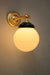Small gold/brass adjustable wall light with ridged opal shade