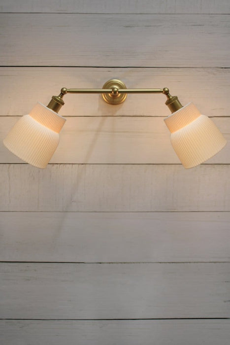  Double swivel arm wall light in gold/brass finish with two ceramic shades