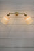  Double swivel arm wall light in gold/brass finish with two ceramic shades