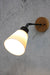 Small ceramic tiltable wall light with a wooden mounting block 