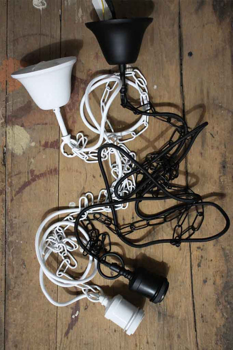 black and white chain pendant cords laying on a timber table