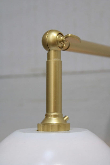 Gold/brass sconce with white shade swivel joint