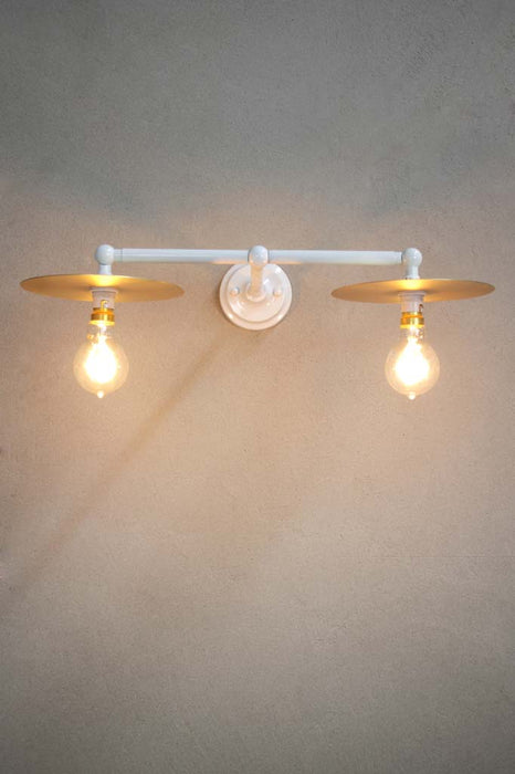 White double arm wall light with small brass discs